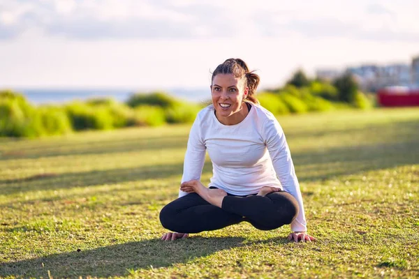 Genç Güzel Sporcu Gülümseyerek Yoga Yapıyor Koç Yüzünde Gülümsemeyle Parkta — Stok fotoğraf