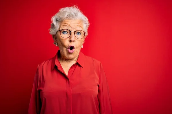Starsza Piękna Siwowłosa Kobieta Luźnej Koszuli Okularach Czerwonym Tle Przerażona — Zdjęcie stockowe