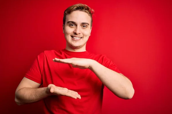 Mladý Pohledný Rusovlasý Muž Neformálním Tričku Izolovaném Červeném Pozadí Gestikuluje — Stock fotografie