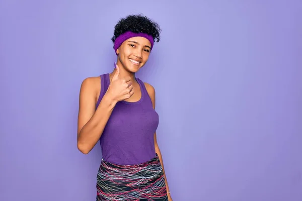 漂亮的非洲裔美国女人穿着休闲的运动服 背景是紫色的 手举着快乐的大拇指 在镜头前看着成功的表情 — 图库照片