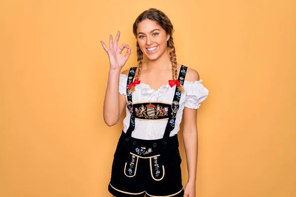 伝統的な10月祭のドレスを着て青い目を持つ若い美しいブロンドのドイツ人女性は 手と指でOkのサインをして肯定的な笑顔 成功した表現 — ストック写真
