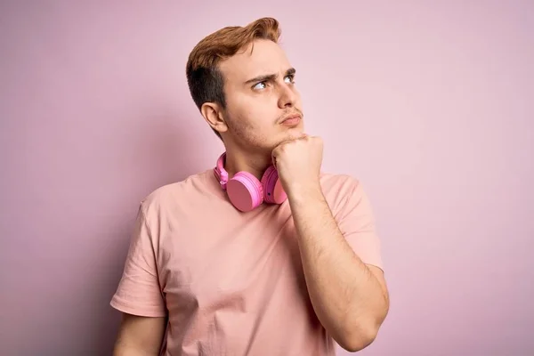 Joven Pelirrojo Guapo Escuchando Música Usando Auriculares Sobre Fondo Rosa —  Fotos de Stock