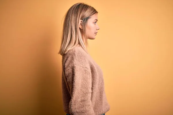 Ung Vacker Blond Kvinna Bär Brun Tröja Över Gul Isolerad — Stockfoto