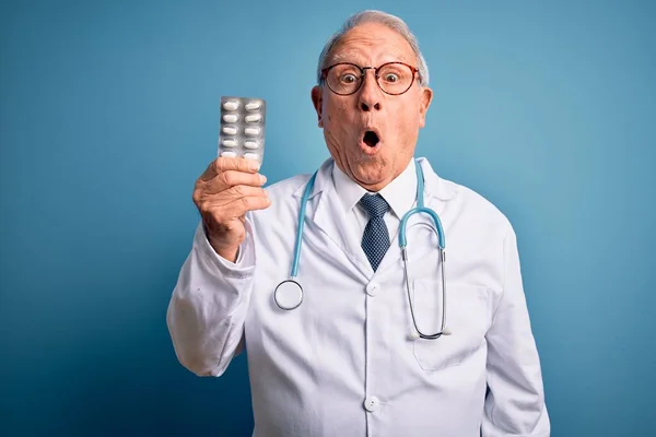 Médico Cabelos Grisalhos Sênior Segurando Pílulas Farmacêuticas Sobre Fundo Azul — Fotografia de Stock