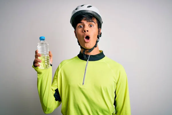 年轻英俊的骑自行车的男子头戴安全帽 喝着一瓶水 吓着了一大跳 吓得面无血色 吓得面无血色 — 图库照片