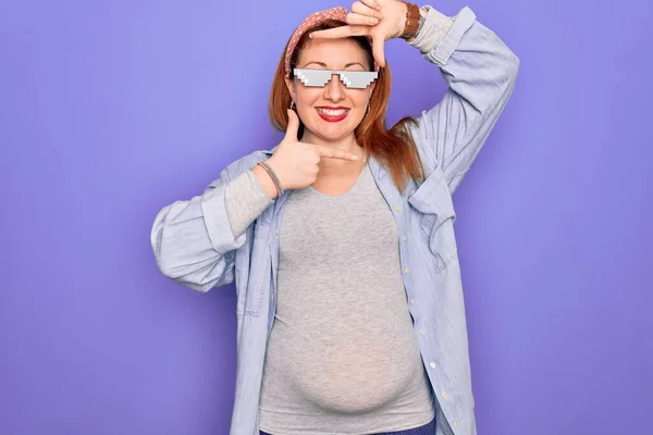 若い赤毛妊娠中の女性は 赤ちゃんが幸せな顔をして手や指でフレームを作る笑顔面白いつま先の人生サングラスを身に着けていることを期待 創造性と写真の概念 — ストック写真
