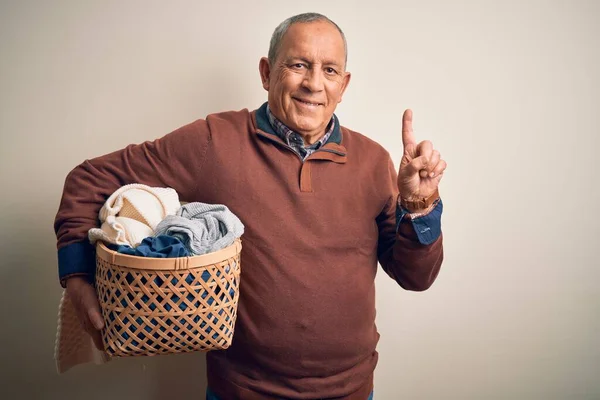 Hombre Guapo Mayor Sosteniendo Canasta Mimbre Con Ropa Sobre Fondo —  Fotos de Stock