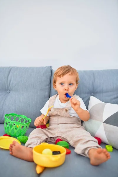 Adorável Criança Loira Sentada Sofá Brincando Com Brinquedos Refeições Plástico — Fotografia de Stock