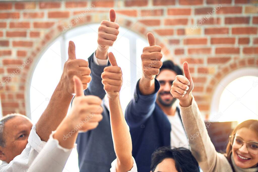 Group of business workers smiling happy. Standing with thumbs up at the office