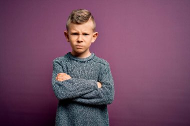 Mavi gözlü, mor arka plan üzerinde duran, kuşkucu ve gergin kolları çaprazlanmış yüz ifadesini tasvip etmeyen, mavi süveter giyen küçük beyaz bir çocuk. Negatif kişi.