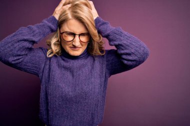 Orta yaşlı, sarışın, sıradan mor balıkçı yaka kazak giyen ve baş ağrısı çeken gözlüklü, çaresiz ve stresli bir kadın. Çünkü ağrı ve migren. Ellerini başının üstüne koy..