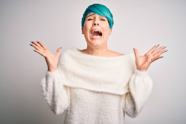 Mavi saçlı genç bir kadın beyaz arka plan üzerine günlük süveter giyerek çılgın ve başarıyı kolları havada ve gözleri kapalı heyecanla haykırarak kutluyor. Kazanan konsept