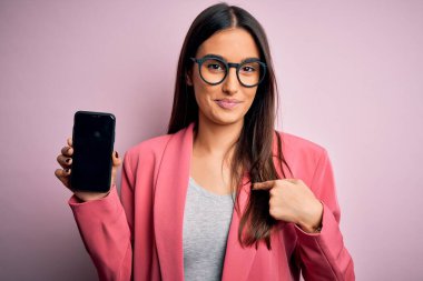 Genç, güzel, esmer, gözlüklü, elinde akıllı telefon, ekranda kendini gösteren sürpriz yüzlü bir kadın.