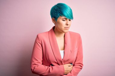 Mavi saçlı, güzel bir iş kadını. Pembe arka planda ceket giyiyor. Midesinde hazımsızlık, acı verici bir hastalık var. Ache kavramı.