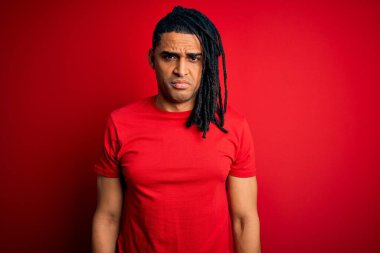 Kırmızı günlük tişörtlü Afro saçlı Afro-Amerikan genç adam depresif ve endişeli, sinirli ve korkmuş. Üzücü ifade.
