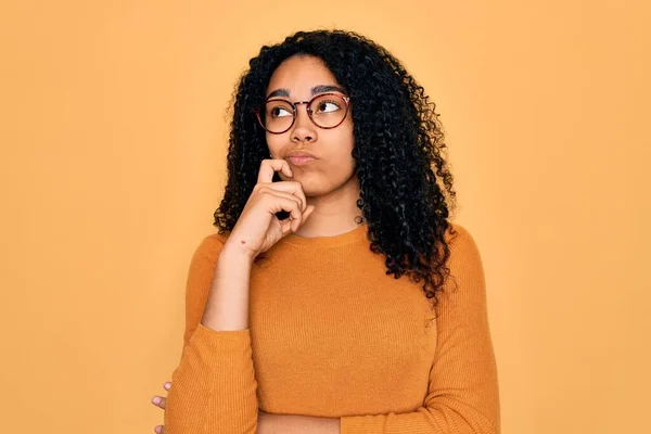 Młoda Afroamerykanka Ubrana Luźny Sweter Okulary Żółtym Tle Ręką Podbródku — Zdjęcie stockowe