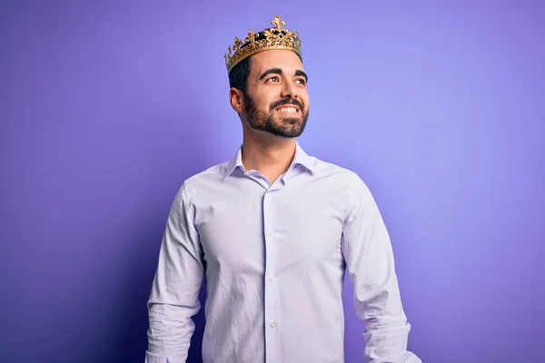 年轻英俊的男人留着胡子 头戴金色的王冠 背景是紫色的 面带微笑 神态自然 充满自信的笑 — 图库照片
