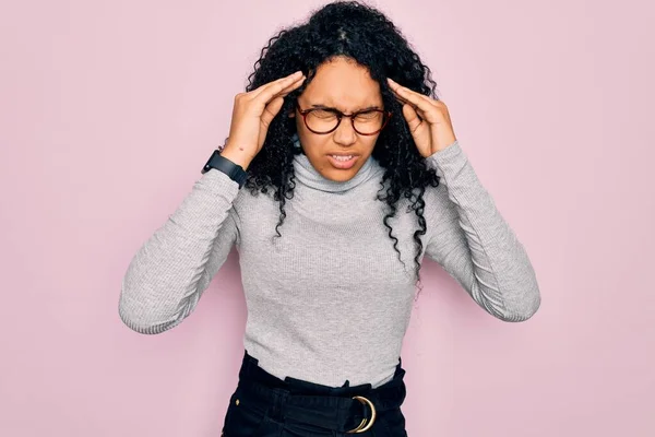 年轻的非洲裔美国女人 穿着高领毛衣 戴着粉色背景的眼镜 手心因压力而头疼 痛苦的偏头痛 — 图库照片