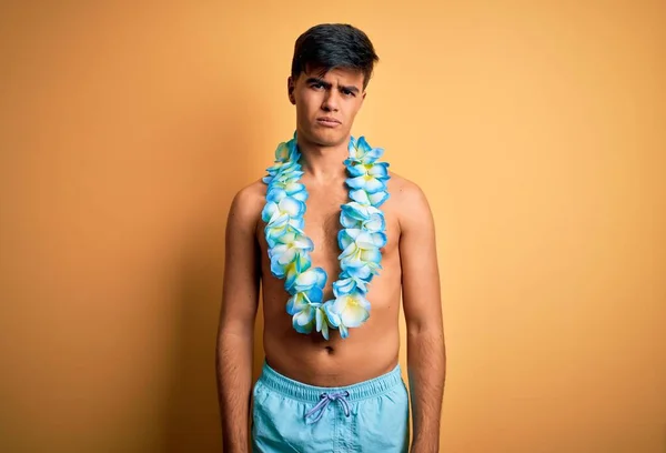 休暇中の若いハンサムな観光客の男性は水着とハワイのレイの花の懐疑的で神経を着て 問題のために動揺を眉をひそめて 負の人 — ストック写真