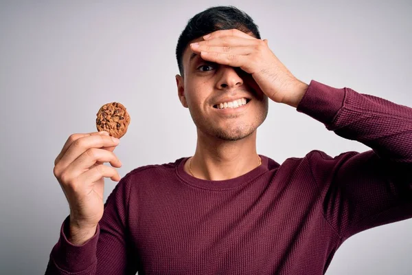 Young Hispanic Man Eating Chocolate Chips Cookie Isolated Background Stressed — Stock Photo, Image