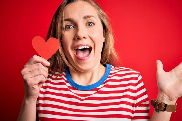 Giovane Bella Donna Bionda Che Tiene Cuore Carta Piedi Sfondo — Foto Stock