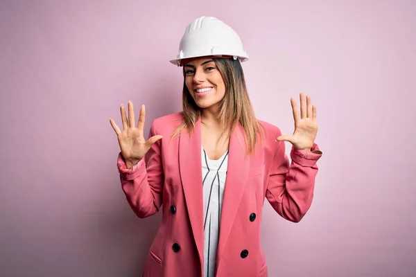 Junge Schöne Brünette Architektin Mit Schutzhelm Auf Rosa Hintergrund Zeigt — Stockfoto