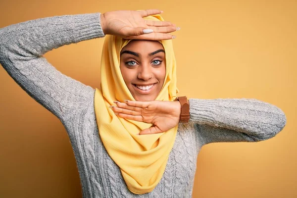Genç ve güzel Afro-Amerikalı kız izole edilmiş sarı arka planda Müslüman başörtüsü takıyor gülümseyen, güler yüzlü, elleri görünen bir yuhalama oyunu oynuyor. Şaşırdım ve çıktım.
