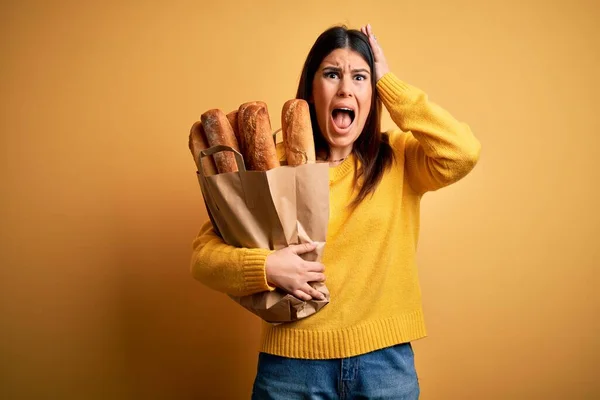 Młoda Piękna Kobieta Trzyma Worek Świeżego Zdrowego Chleba Żółtym Tle — Zdjęcie stockowe
