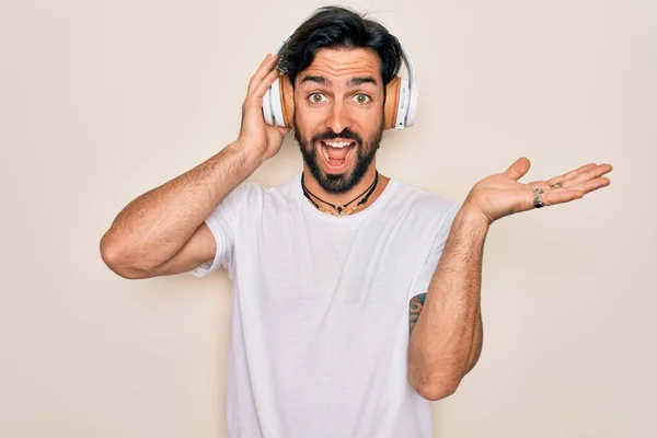 Νεαρός Όμορφος Ισπανός Άνδρας Φορώντας Ακουστικά Ακούγοντας Μουσική Απομονωμένο Φόντο — Φωτογραφία Αρχείου