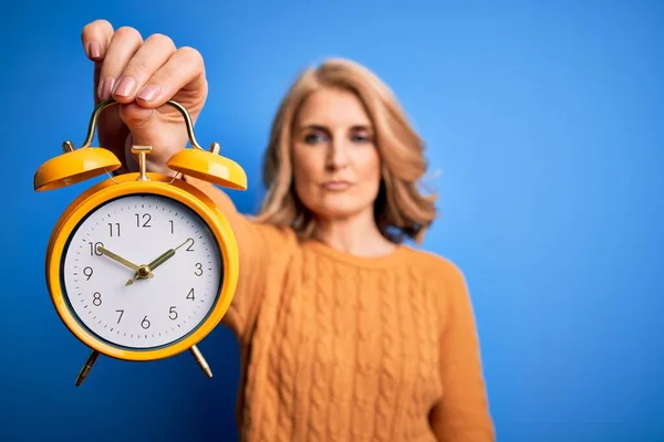 Middle Age Beautiful Blonde Woman Holding Vintage Alarm Clock Blue — Stock Photo, Image