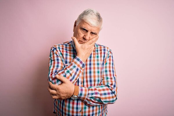 Senior handsome hoary man wearing casual colorful shirt over isolated pink background thinking looking tired and bored with depression problems with crossed arms.