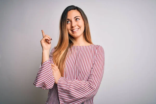 Mavi gözlü, genç, güzel, sarışın bir kadın. Beyaz arka plan üzerinde ince tişört giyiyor. Yüzünde kocaman bir gülümseme var..