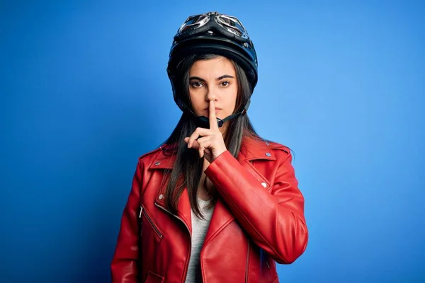 若い美しいブルネットのオートバイのヘルメットとジャケットを身に着けている女性は唇に指で静かになるように求めている 沈黙と秘密の概念 — ストック写真