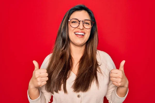 Νεαρή Ισπανίδα Έξυπνη Γυναίκα Φορώντας Γυαλιά Στέκεται Πάνω Από Κόκκινο — Φωτογραφία Αρχείου