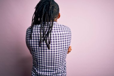 Rasta desenli tişörtlü Afro-Amerikan genç, yakışıklı Afro-adam. Kendine mutlu ve olumlu bir şekilde sarılıyor. Sevgi ve özgüven.