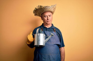 Orta yaşlı çiftçi önlük ve şapka tutan bir adam sarı arka planda su dolu bir teneke kutu taşıyordu. Akıllı yüzünde kendine güvenen bir ifade vardı ve ciddi düşünüyordu.