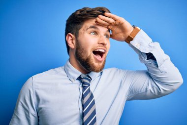 Sakallı, mavi gözlü, şık gömlekli ve kravatlı genç sarışın işadamı mutlu ve tebessüm ediyor. Konsept aranıyor.