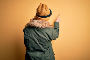 Orta yaşlı güzel sarışın kayakçı kadın kar sporu giysisi ve kayak gözlüğü takıyor.