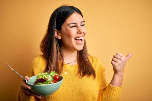 Young Beautiful Woman Eating Healthy Fresh Salad Yellow Background Pointing — Stock Photo, Image