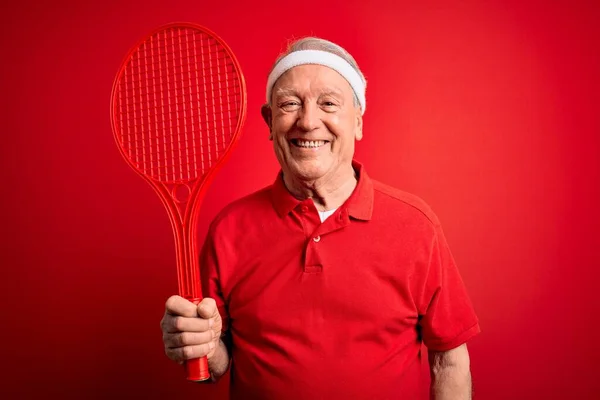Homem Tenista Cabelos Grisalhos Seniores Segurando Raquete Sobre Fundo Vermelho — Fotografia de Stock