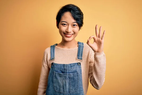 Mladá Krásná Asijská Dívka Sobě Ležérní Džínové Kombinézy Přes Izolované — Stock fotografie