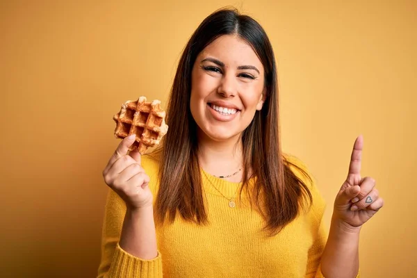 Sarı Arka Planda Tatlı Waffle Yiyen Genç Güzel Bir Kadın — Stok fotoğraf