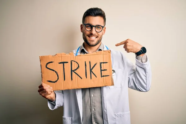 Young Handsome Doctor Man Protesting Holding Cardboard Strike Message Surprise — Stock Photo, Image