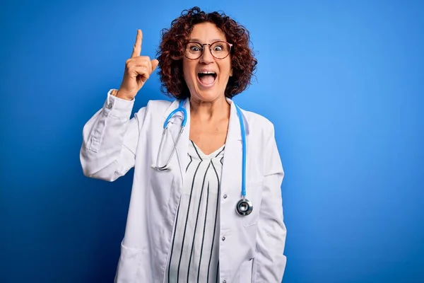 Kobieta Średnim Wieku Kręcone Włosy Lekarz Noszący Płaszcz Stetoskop Niebieskim — Zdjęcie stockowe