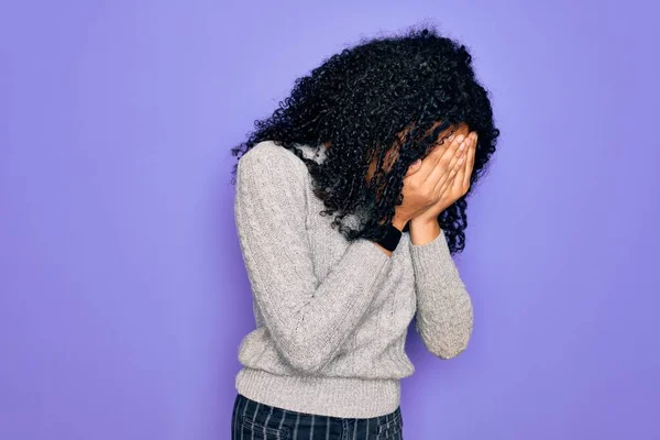 泣きながら手で顔を覆う悲しい表情で紫色の背景にカジュアルなセーターと眼鏡を身に着けている若いアフリカ系アメリカ人女性 うつ病の概念 — ストック写真