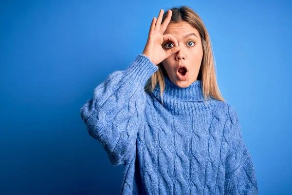 Mladá Krásná Blondýnka Zimním Vlněném Svetru Modrém Izolovaném Pozadí Dělá — Stock fotografie