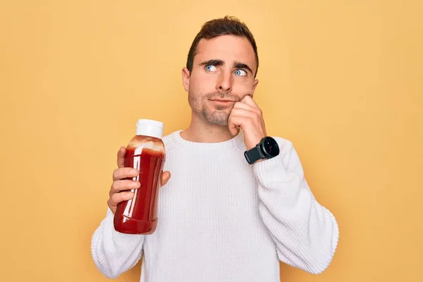 Young Handsome Man Holding Bottle Ketchup Sauce Condiment Yellow Background — Stock Photo, Image