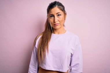 Pembe izole edilmiş arka plan üzerine kazak giyen genç ve güzel bir bayan üzgün, sinirli ve korkmuş bir şekilde ağlıyor. Üzücü ifade.