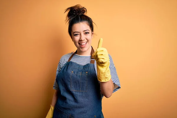 Junge Brünette Putzfrau Mit Haushaltshandschuhen Über Gelbem Hintergrund Macht Eine — Stockfoto