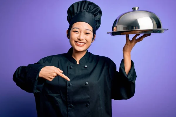 年轻美丽的中国厨师女士身穿炊具制服 头戴圆顶礼帽 手指指向自己 令人惊讶 — 图库照片